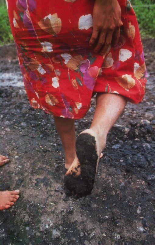  Femme indigène marchant sur une route couverte de pétrole Amazonie équatorienne